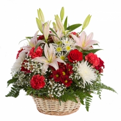 Белые лилии и хризантемы, красные розы и гвоздики в корзине с зеленью